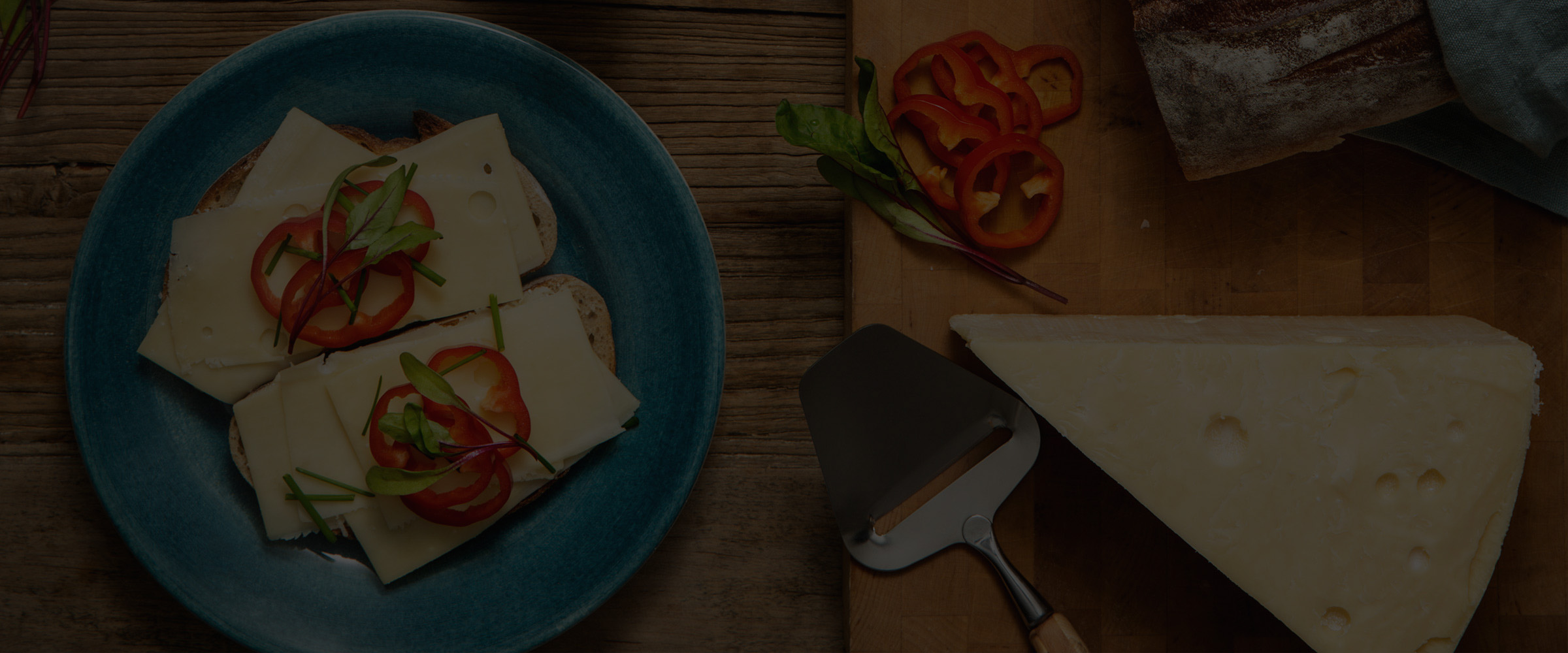 Herrgårdsost på ett bord tillsammans med smörgåsar